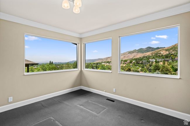 Unfurnished room with a mountain view, a chandelier, dark carpet, and crown molding | Image 13