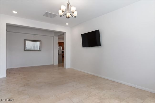Den with recessed lighting, a notable chandelier, and baseboards. Table/personal items removed virtually for picture. | Image 38
