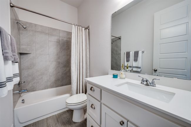 Full bath with toilet, shower / bath combo with shower curtain, wood finished floors, and vanity | Image 22