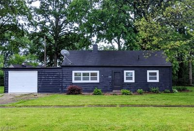 View of front of home featuring a front yard and a garage | Image 1