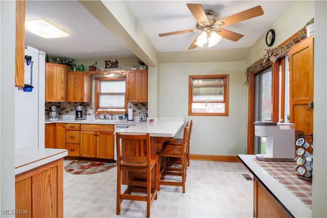 Kitchen featuring a healthy amount of sunlight, a kitchen breakfast bar, and light floors | Image 16