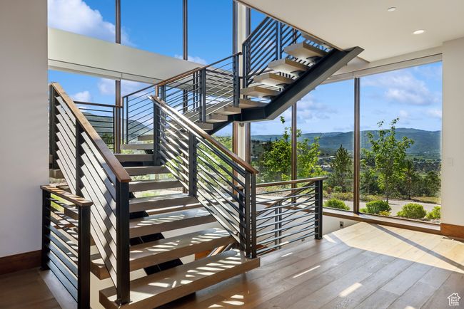 Staircase with hardwood / wood-style floors, a mountain view, healthy amount of natural light, recessed lighting, and baseboards | Image 25