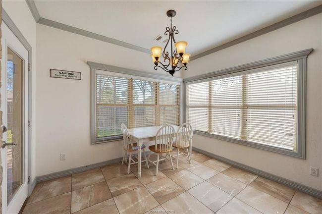 Dining space with crown molding and a chandelier | Image 10