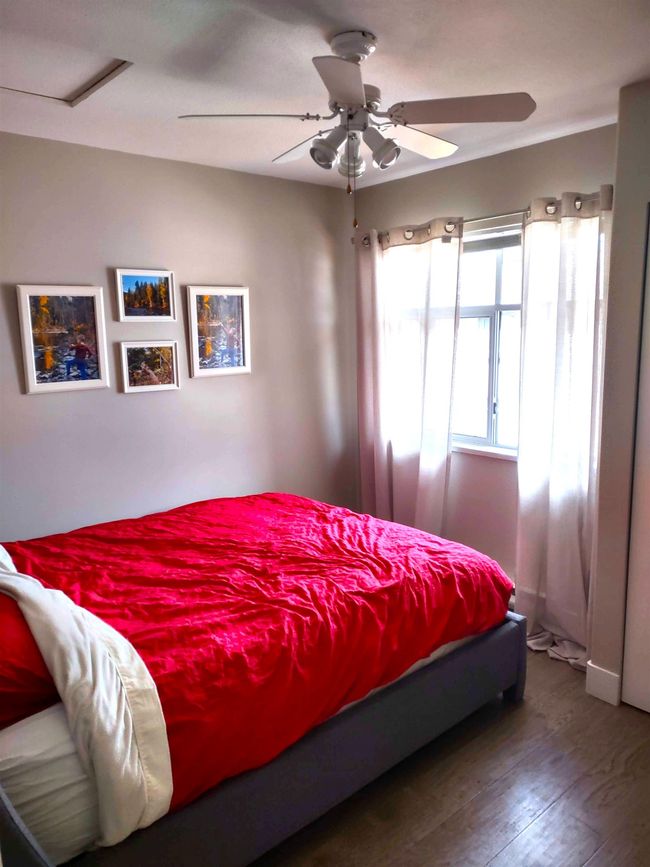 Bedroom featuring attic access, a ceiling fan, and wood finished floors | Image 15