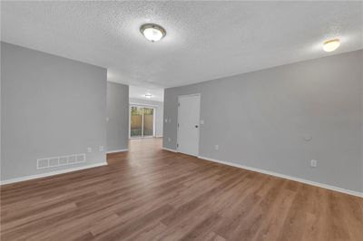 Spare room with a textured ceiling and hardwood / wood-style flooring | Image 3