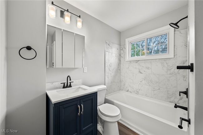 Bathroom featuring wood finished floors, toilet, shower combination, and vanity | Image 23