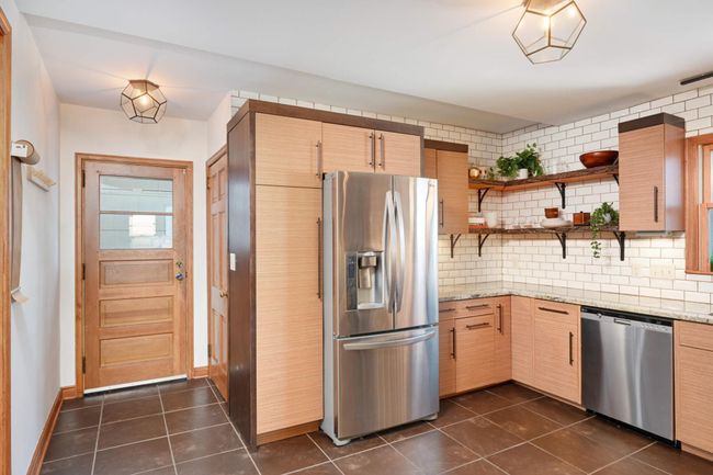 The kitchen is host to the back door, which offers a wide entry way. | Image 13