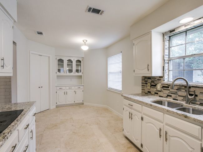 Kitchen featuring a sink, backsplash, black electric stovetop, and plenty of natural light | Image 7