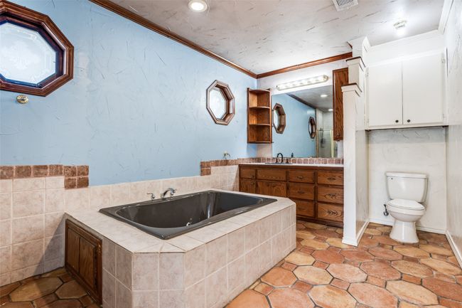 Full bathroom with crown molding, toilet, a jetted tub, and vanity | Image 26