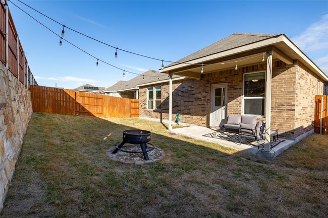 Back of house with an outdoor space with a fire pit, a patio, and a yard | Image 6