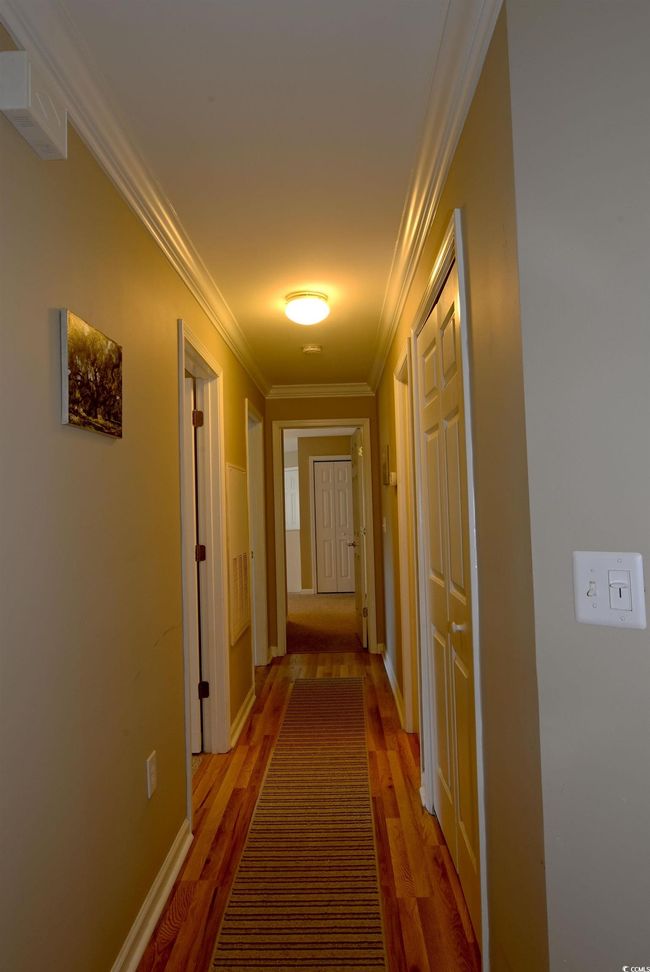 Corridor with crown molding and wood-type flooring | Image 16
