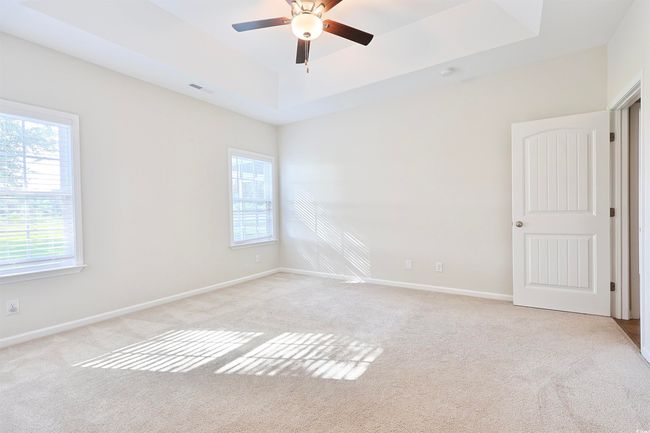 Spare room with a tray ceiling, light carpet, and a ceiling fan | Image 10