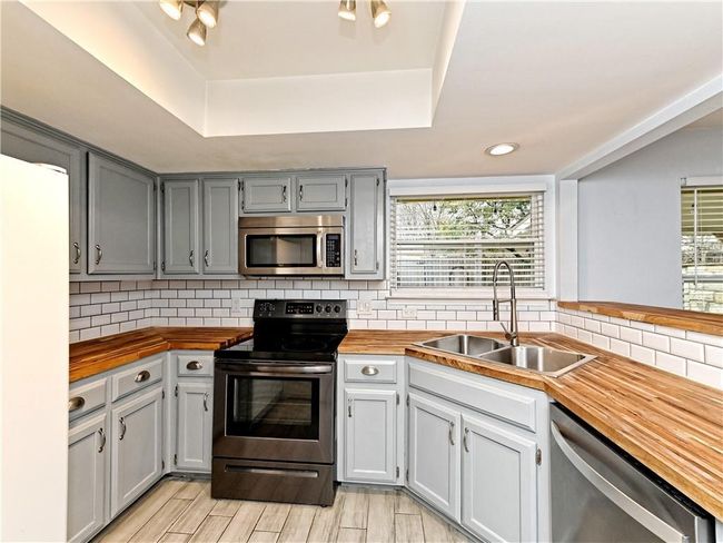 Kitchen with stainless steel appliances, butcher block counters, plenty of natural light, and recessed lighting | Image 28