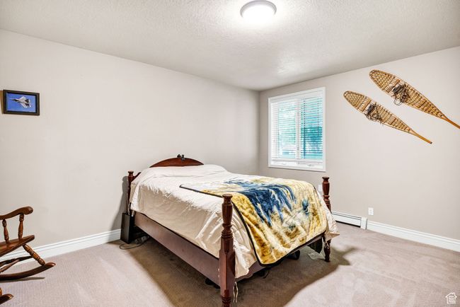 Carpeted bedroom with a baseboard radiator and a textured ceiling | Image 51