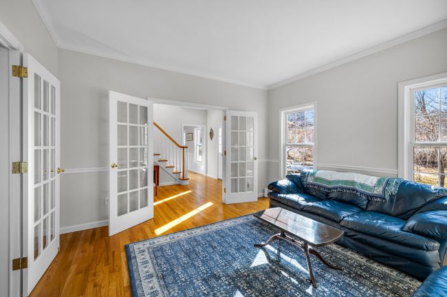 Living room off foyer with crown molding, chair rail, and French doors. Can easily function as a home office. | Image 5