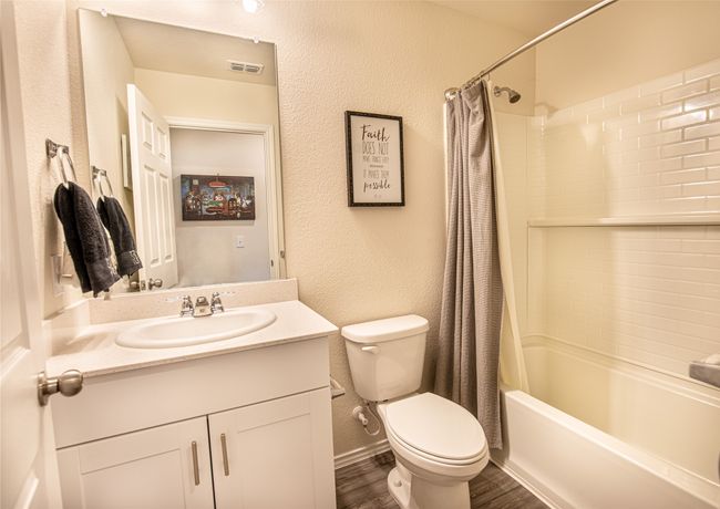 Bathroom with vanity, wood finished floors, shower / tub combo with curtain, and a textured wall | Image 25