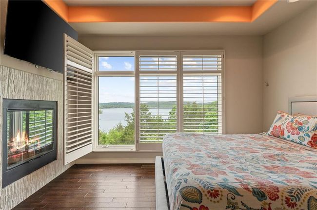 Bedroom featuring a water view, baseboards, and dark wood finished floors | Image 26