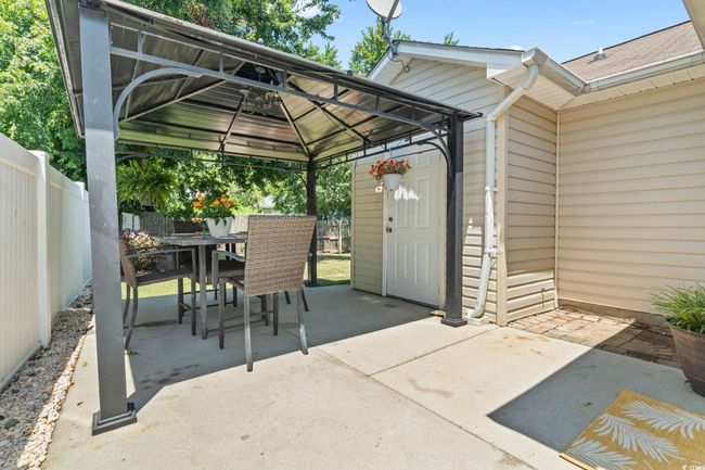 Fenced backyard with a patio area, outdoor dining space, and a gazebo | Image 28