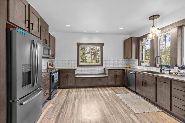 Kitchen with a wealth of natural light, light wood-style floors, stainless steel appliances, and a sink | Image 4
