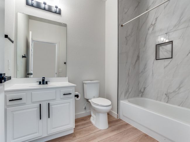 Full bath featuring vanity, wood finished floors, and tub / shower combination | Image 22