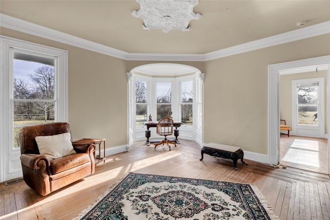 Living area featuring arched walkways, visible vents, baseboards, ornamental molding, and light wood finished floors | Image 8