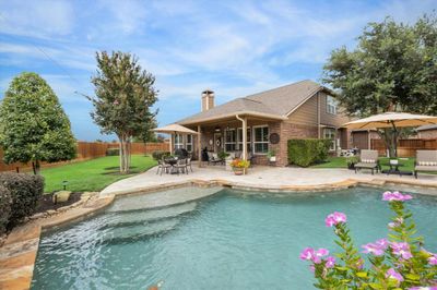 Sparkling pool boasts in-floor cleaning system, pebble-tech plaster, bubblers + waterfall feature (3 falls) and pool lights. Lush landscaping in this oh so lovingly cared for yard space. | Image 2