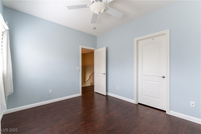 Bedroom with dark wood-style floors, ceiling fan, and baseboards | Image 19