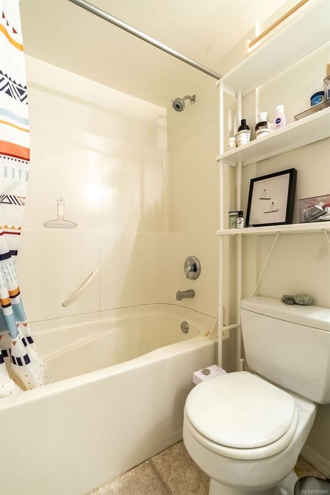 Bathroom featuring tile patterned floors, toilet, and shower / tub combo with curtain | Image 10