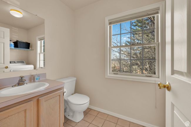 Half bath with tile patterned flooring, vanity, toilet, baseboards, and washer / clothes dryer | Image 11