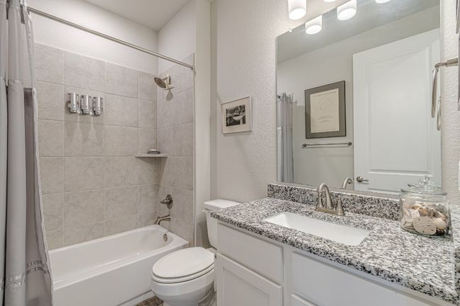 Full bath featuring vanity, shower / bath combination with curtain, and a textured wall | Image 21