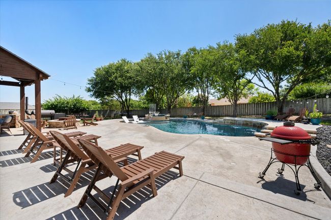 View of swimming pool featuring a fenced backyard, a patio area, and a pool with connected hot tub | Image 25