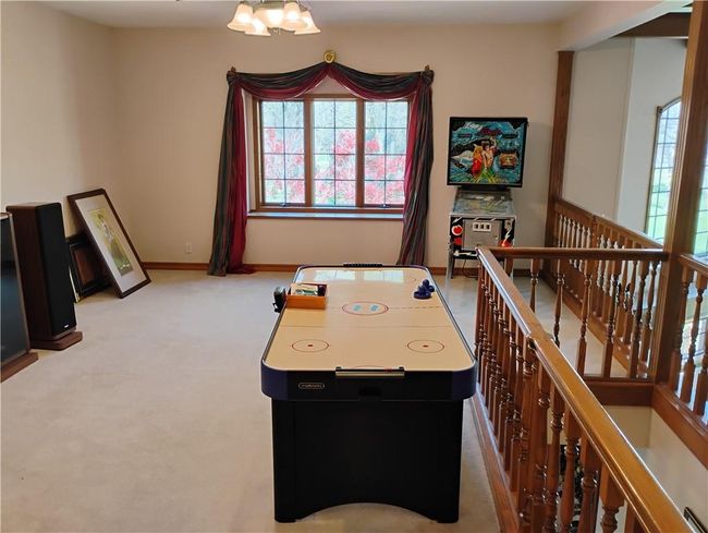 Upstairs Rec room featuring a notable chandelier, oak baseboards, and light carpet | Image 65