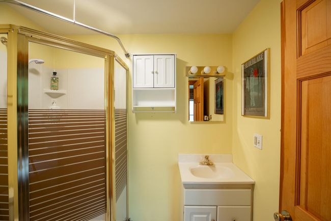 Bathroom featuring a shower with shower door and vanity | Image 14