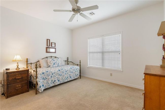 Bedroom featuring visible vents, light colored carpet, baseboards, and ceiling fan | Image 41