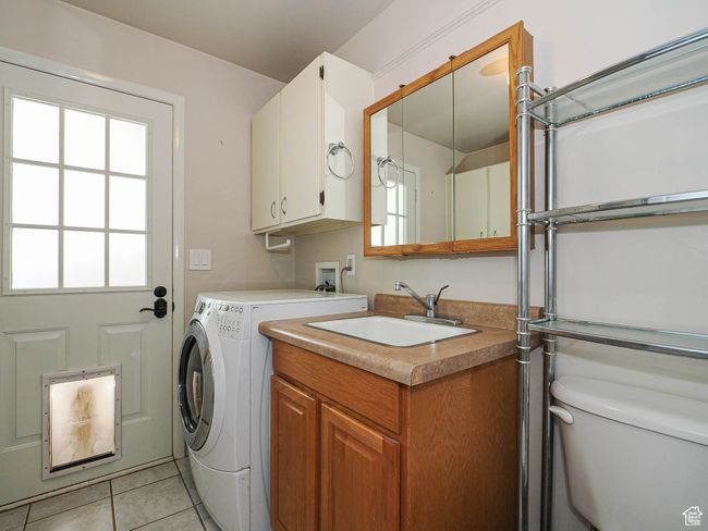 Laundry area featuring a sink, light tile patterned flooring, and washer and dryer | Image 26