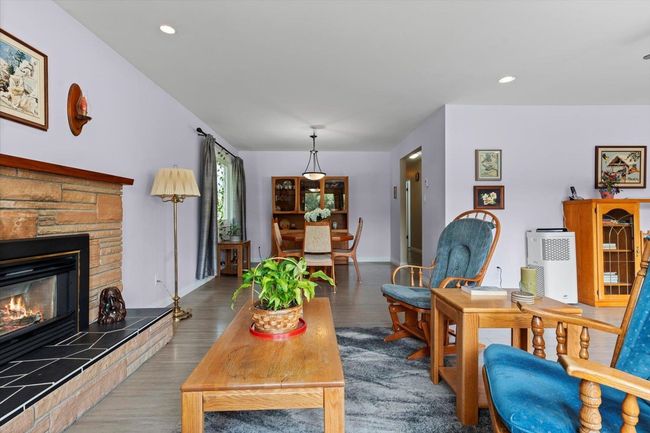 Living room with wood finished floors, a fireplace, and recessed lighting | Image 16