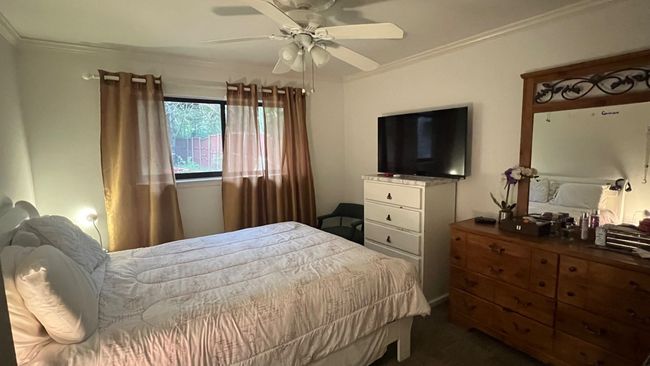 Bedroom featuring crown molding, dark carpet, and a ceiling fan | Image 9