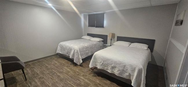Bedroom with wood finished floors and a paneled ceiling | Image 31