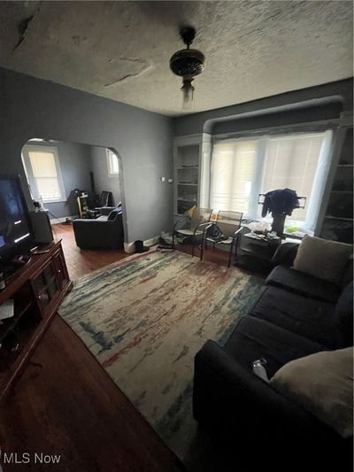 Living room featuring wood-type flooring, ceiling fan, and a textured ceiling | Image 3