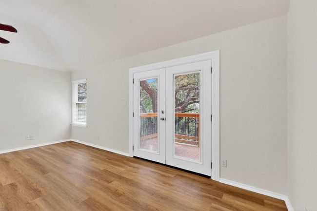 Spare room featuring ceiling fan, wood finished floors, french doors, lofted ceiling, and baseboards | Image 16