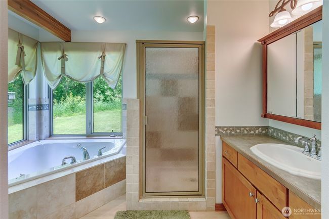 Primary bathroom with large jetted soaking tub and tiled shower. | Image 13