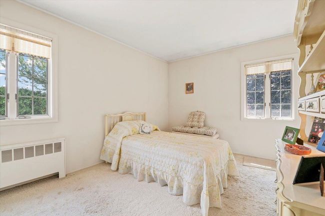 Bedroom featuring radiator heating unit and carpet floors | Image 18