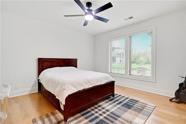 Bedroom featuring light wood-style flooring, visible vents, a ceiling fan, and baseboards | Image 58