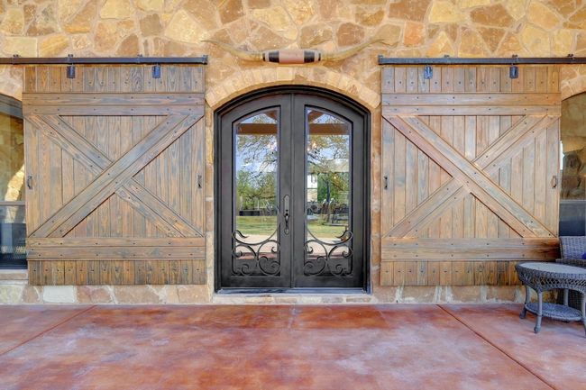 Wrought iron doors flanked by custom barn door shutters for the windows! | Image 36