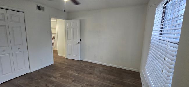 Unfurnished bedroom featuring dark wood-style floors and a closet | Image 7
