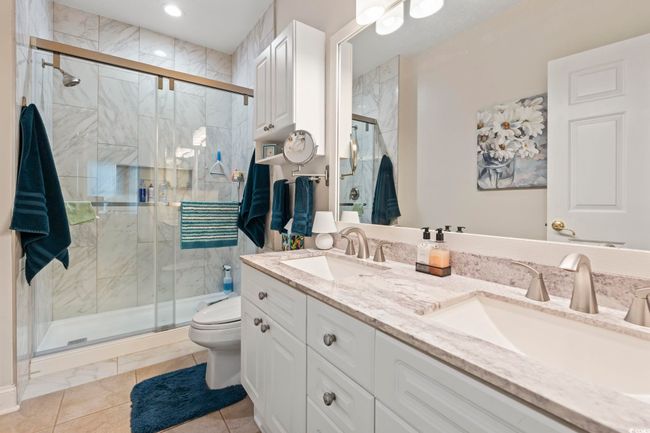 Full bath featuring double vanity, a shower stall, and tile patterned floors | Image 7