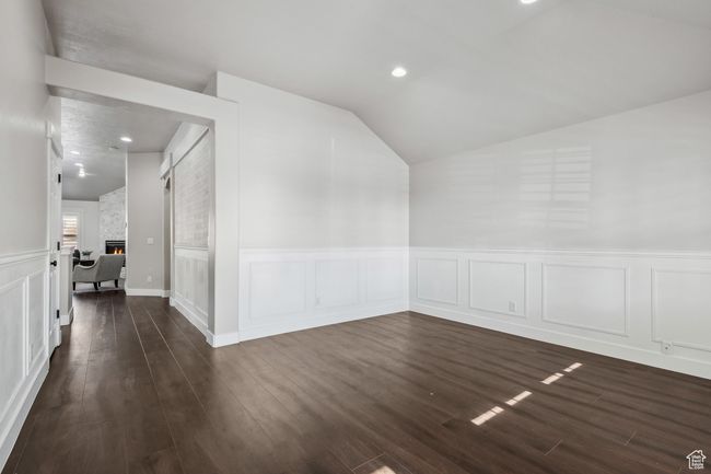 Living room with lofted ceiling, a fireplace, and dark wood-type flooring | Image 4