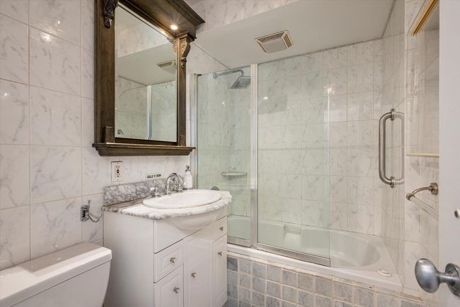 Full bath featuring tile walls, toilet, tiled shower / bath, and vanity | Image 11