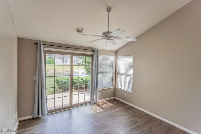 Spare room featuring vaulted ceiling, wood finished floors, and ceiling fan | Image 21