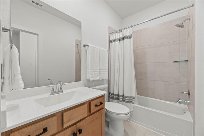 Secondary bathroom with a large vanity and a tub/shower combination. | Image 16